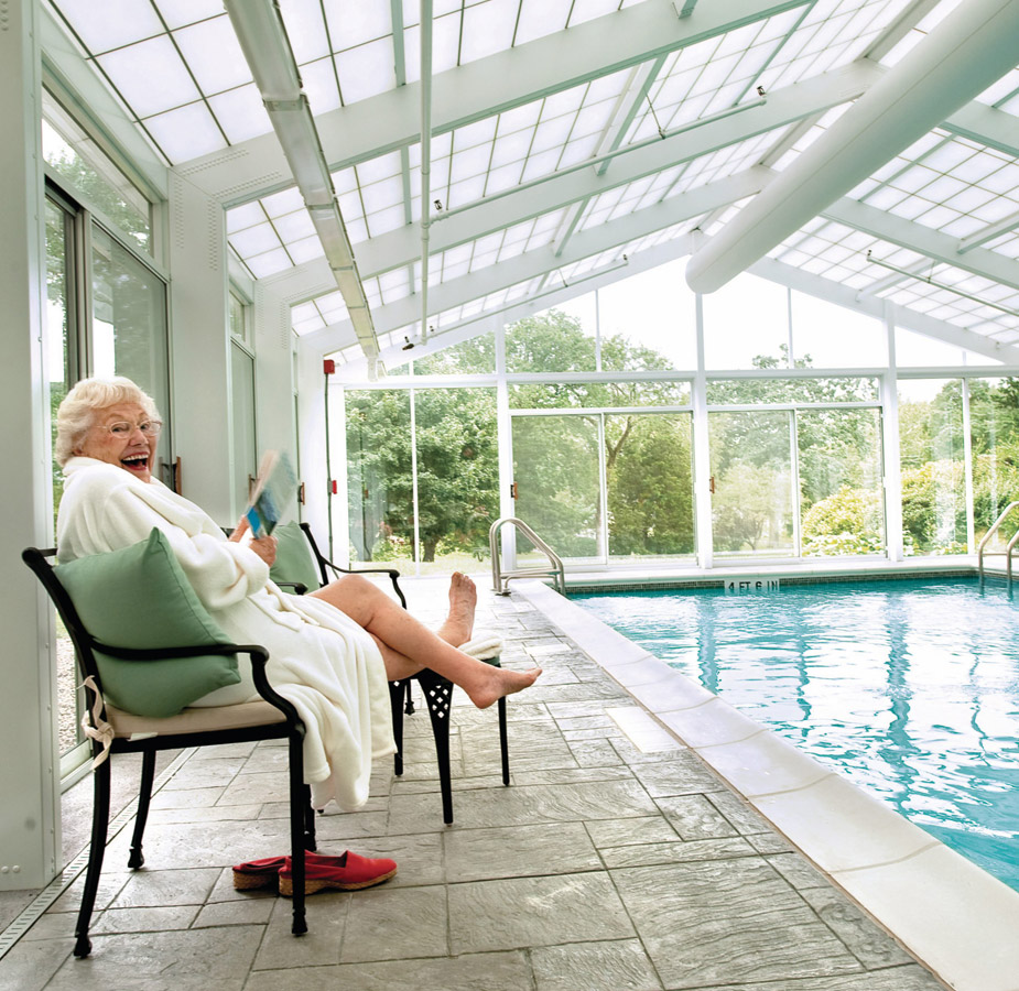 A resident is reading by the pool.