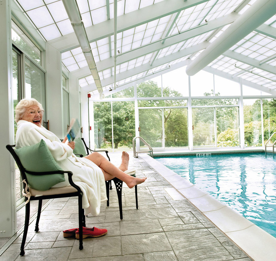 A resident is reading by the pool.