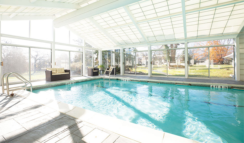 enclosed pool with patio furniture surrounding pool perimeter