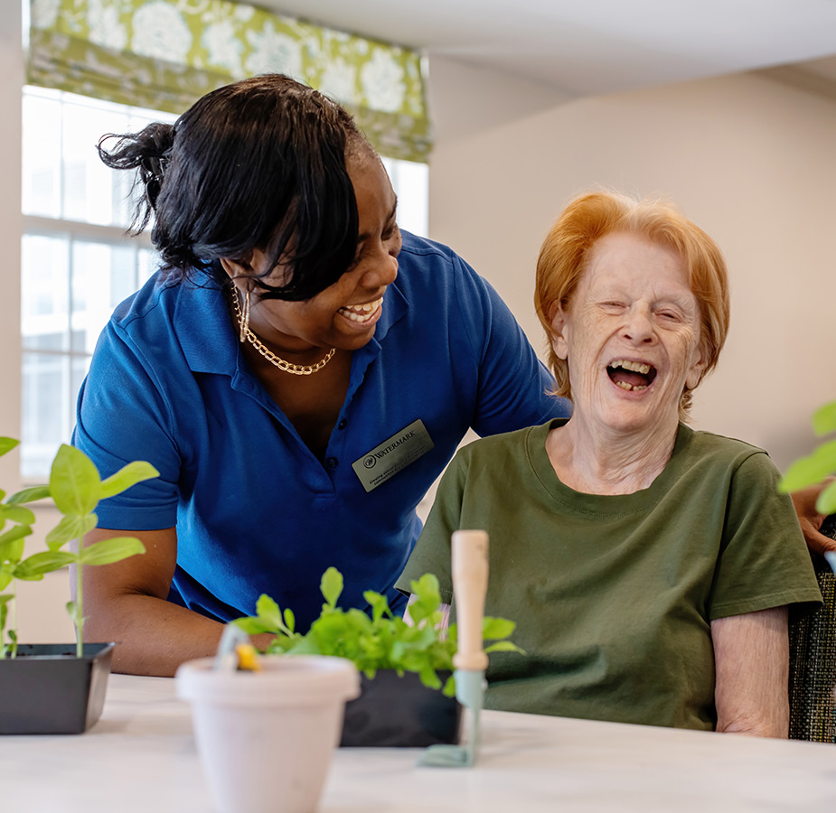 A caregiver helping a resident with plants.