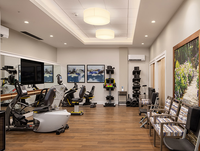 A fitness center with plenty of exercise equipment.