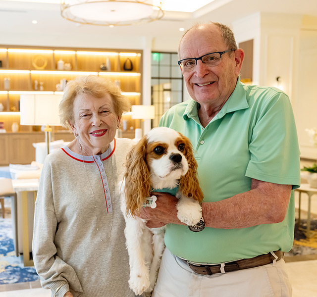 Two people holding their dog.