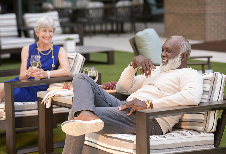 Two residents are sitting outside at The Watermark at Coral Gables.