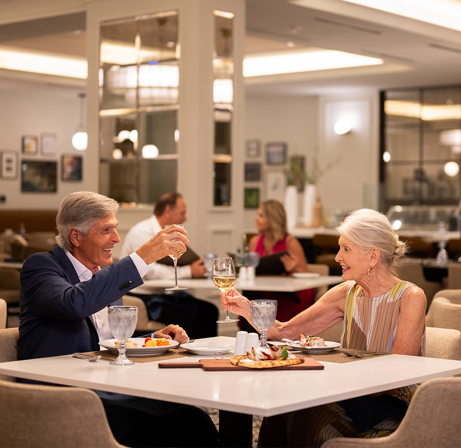 A couple toasting at dinner.