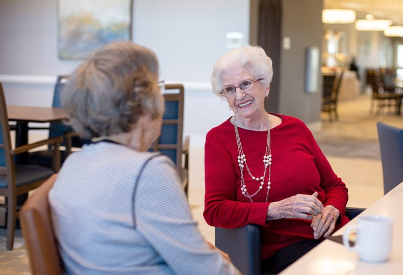 Two residents sit and talk.