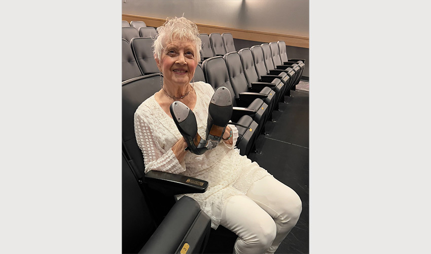 A person holding up a pair of tap shoes.