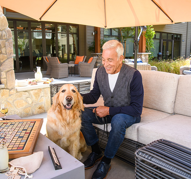 A resident is sitting outside with their dog.
