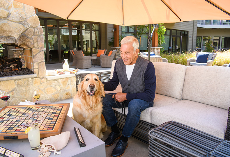 A resident is sitting outside with their dog.
