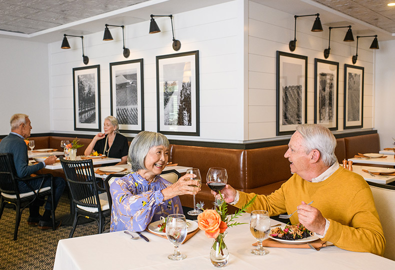 Two residents are having their meals together in the dining area at The Watermark at Napa Valley.