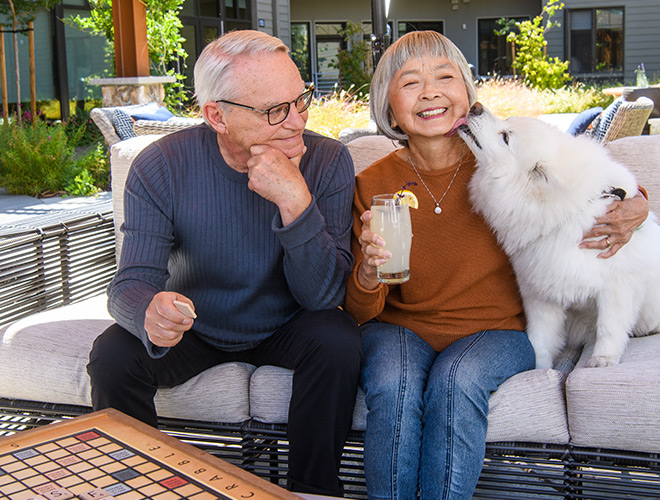 Two residents are sitting outside with their dog.