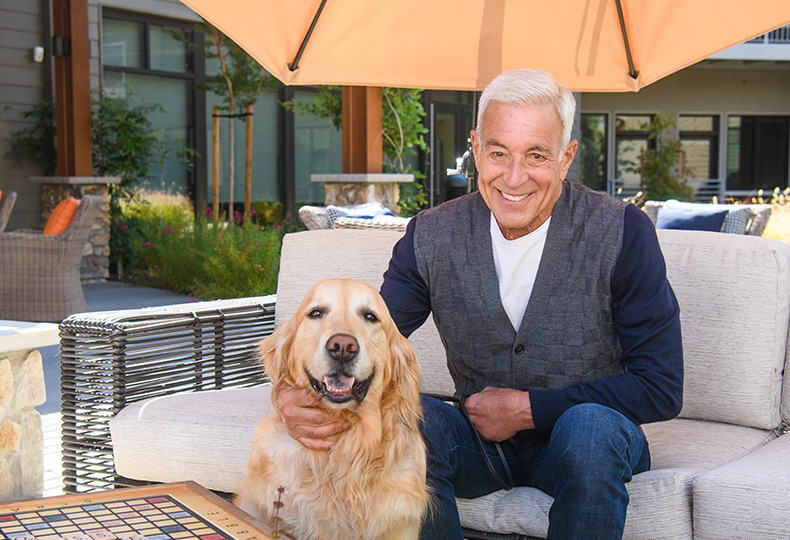 A resident is sitting outside with their dog.