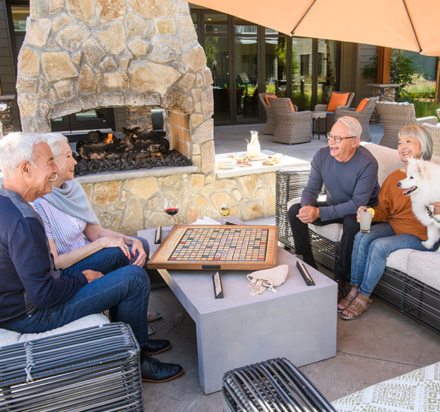 Residents are sitting outside playing a letters game together.