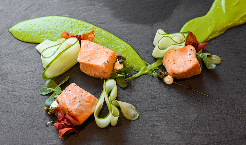 Salmon artistically displayed on a plate.