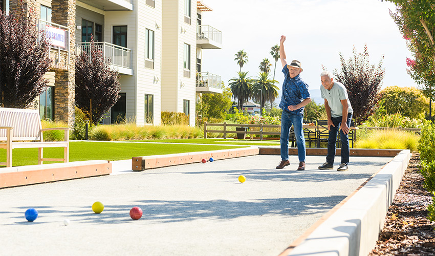 Two people playing bocce ball.