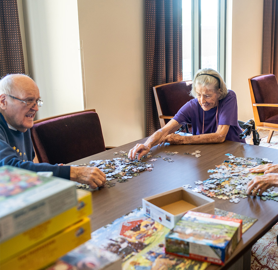 Two residents are building a puzzle.