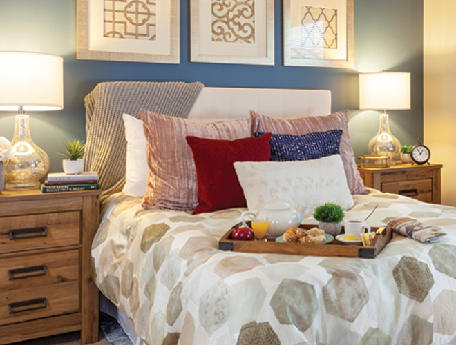 Bedroom with a bed, dresser, and wall art.