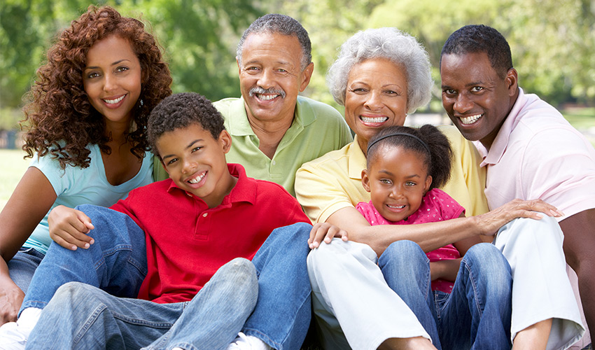 multigenerational family photo sitting outside on the grass