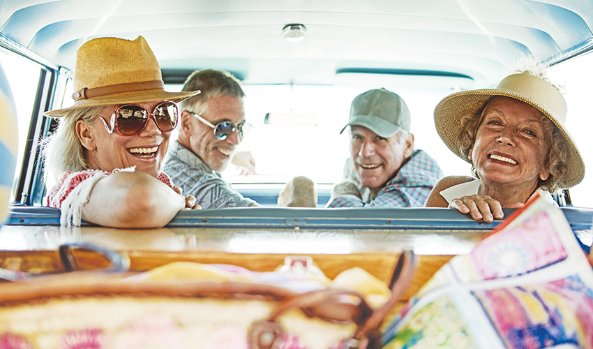 four friends smiling in a car together