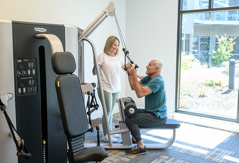 A resident is using a fitness machine.