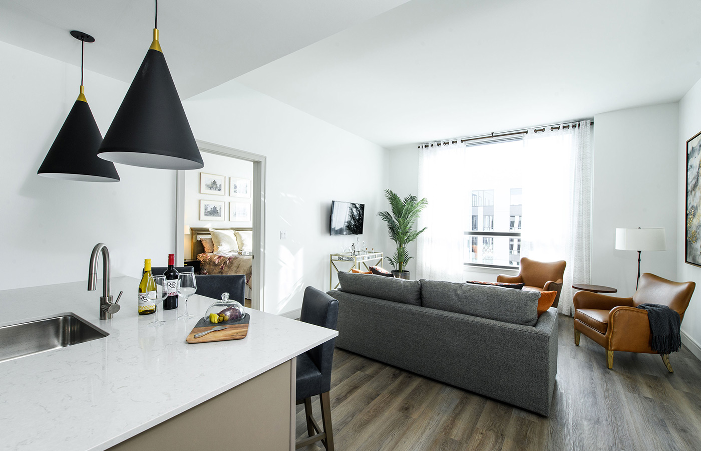 A furnished model apartment kitchen looking in to the living room.