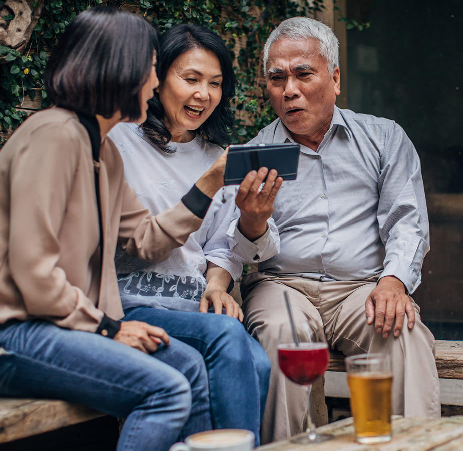 Three people are looking at a phone.