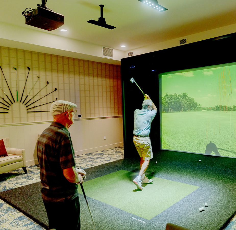 Two people playing a golf simulator.
