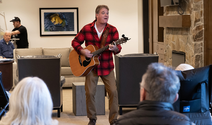 People listening to a person playing guitar.