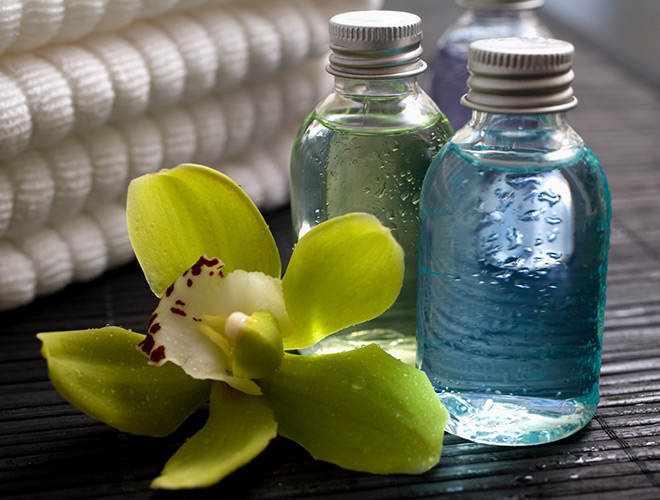 close up of glass spa bottles and a lily flower