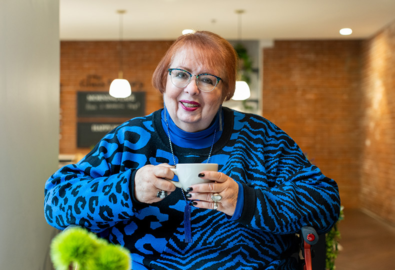 A resident is holding a cup of coffee.