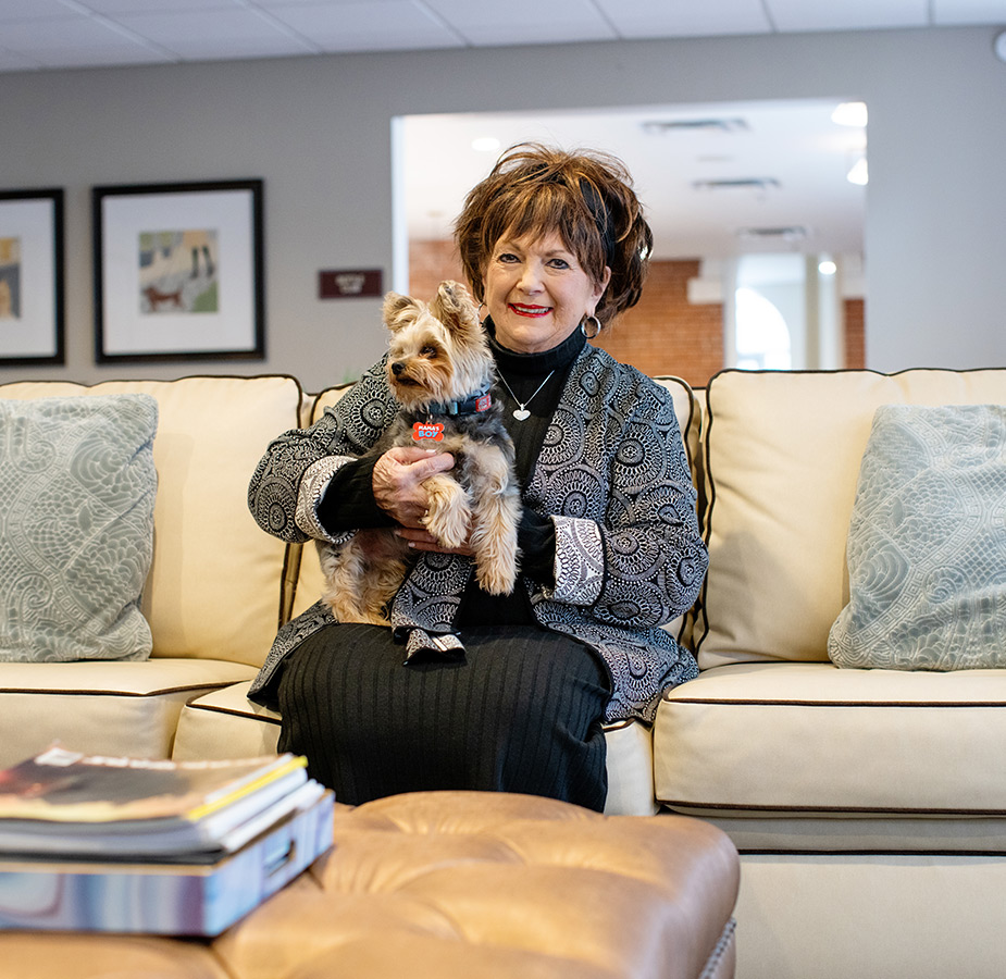 A resident is holding a dog.