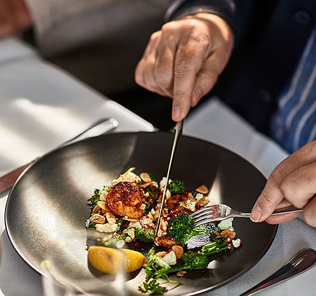 Resident cutting into their plated meal.