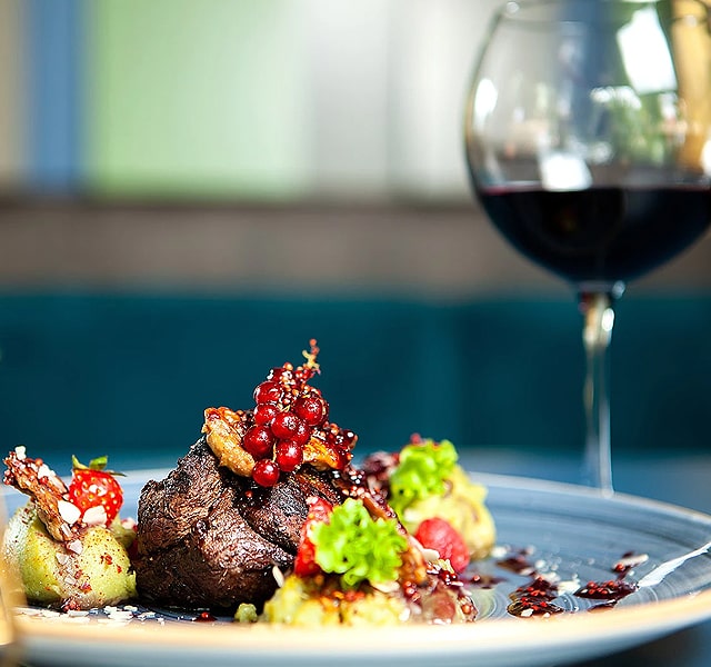 Plated meal displayed artistically with a glass of wine.
