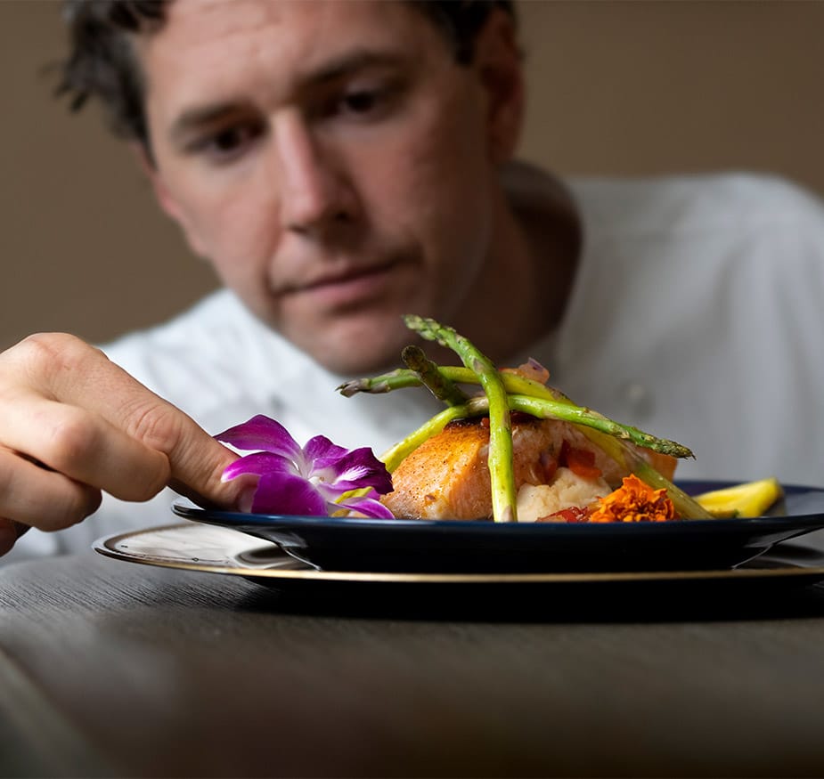 Chef preparing a dish of food.