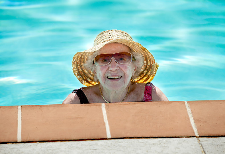 A female resident smiling from the pool