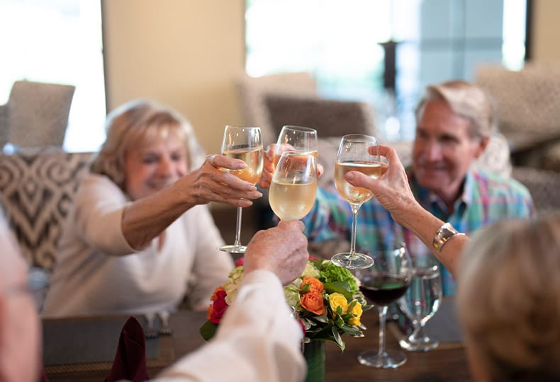 Residents toasting with a glass of wine.