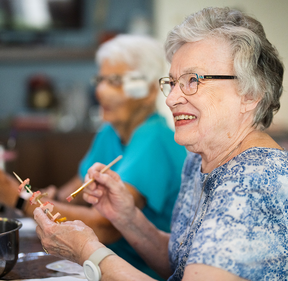 Residents enjoying an art class with canvases and paint brushes.