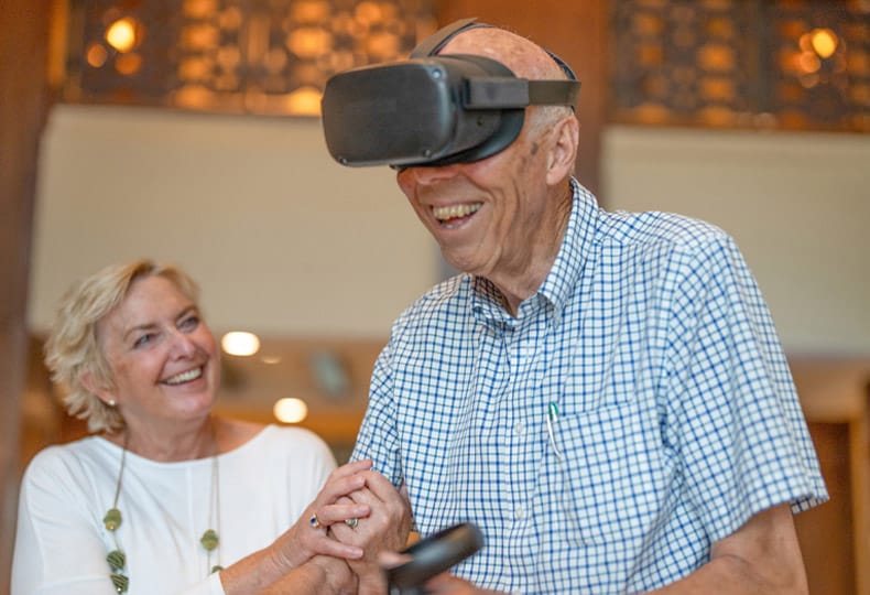 Residents laughing while enjoying virtual reality event.