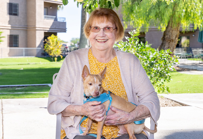 A resident smiling with their dog.