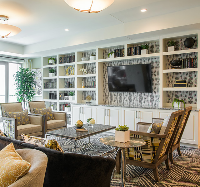 Furnished lobby area of Seneca with chairs and a television.