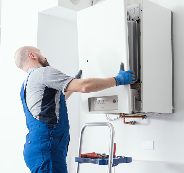 A person is fixing a water heater.
