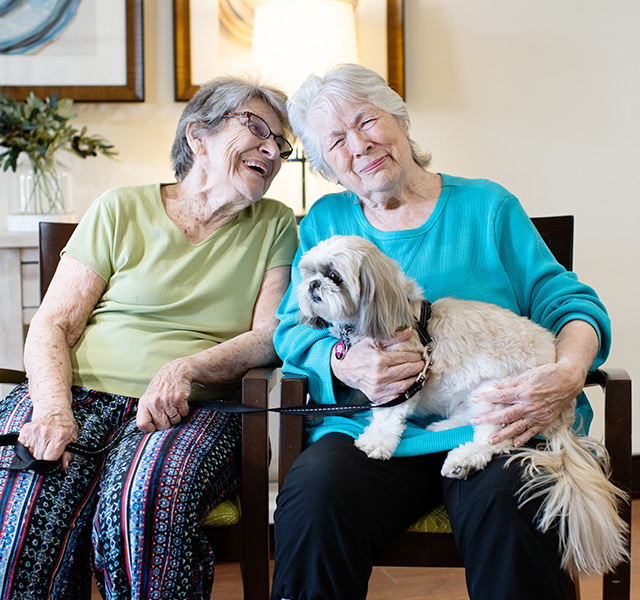 Two people with a dog on the couch.