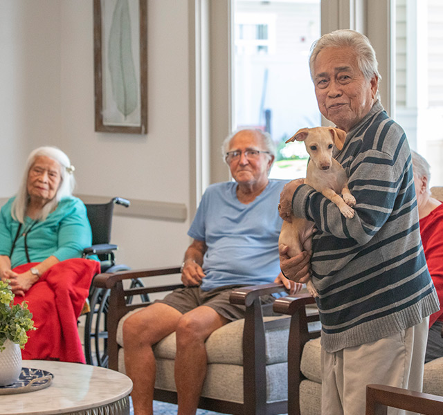 A resident holding a small dog.
