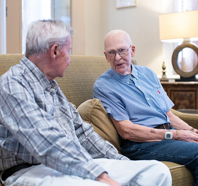 Two residents are sitting on a sofa and talking.