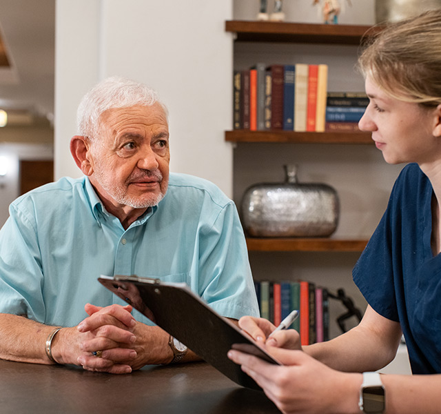 A medical professional talking with a resident.