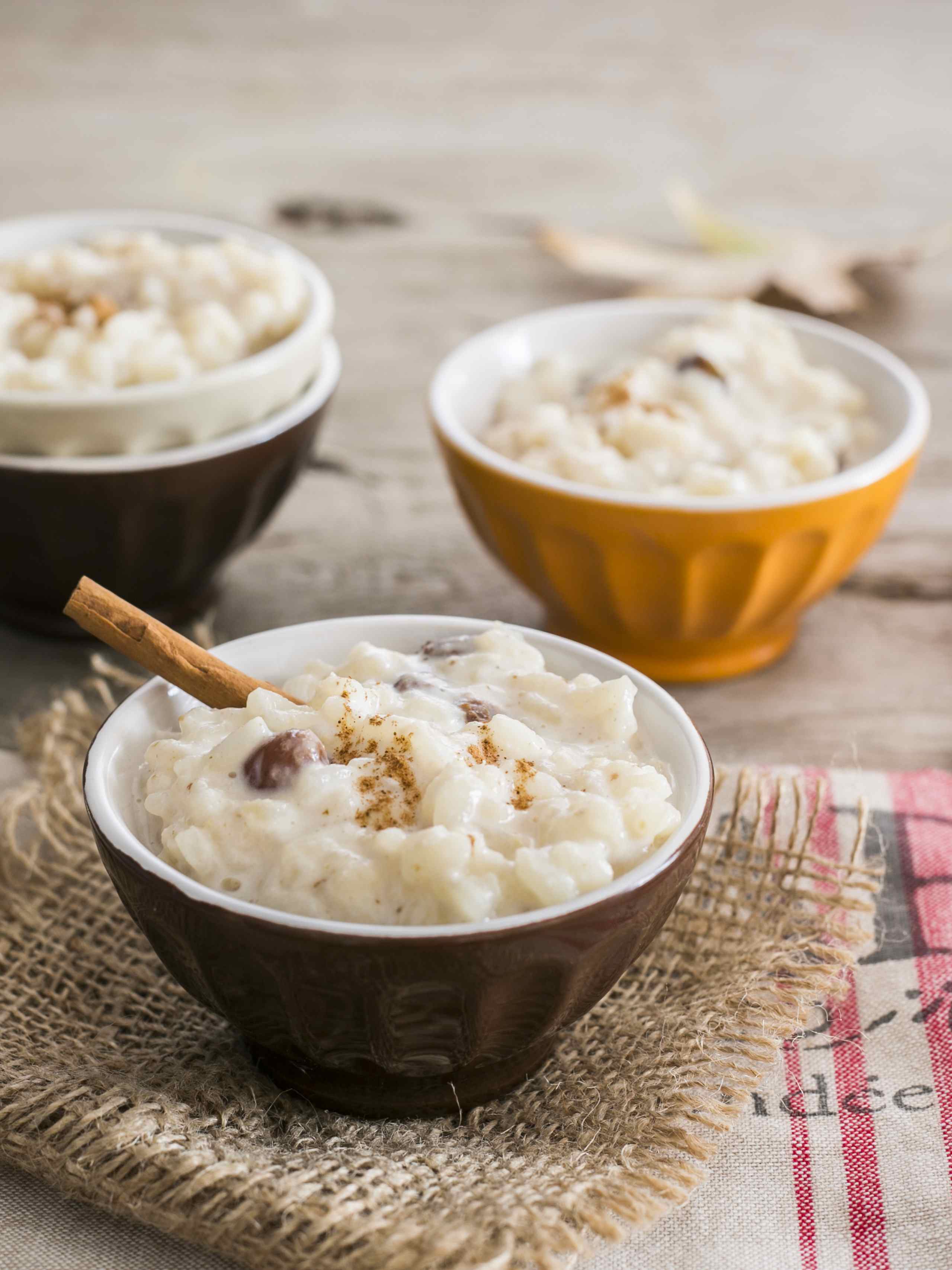 Three bowls of rice pudding with cinnamon on top.