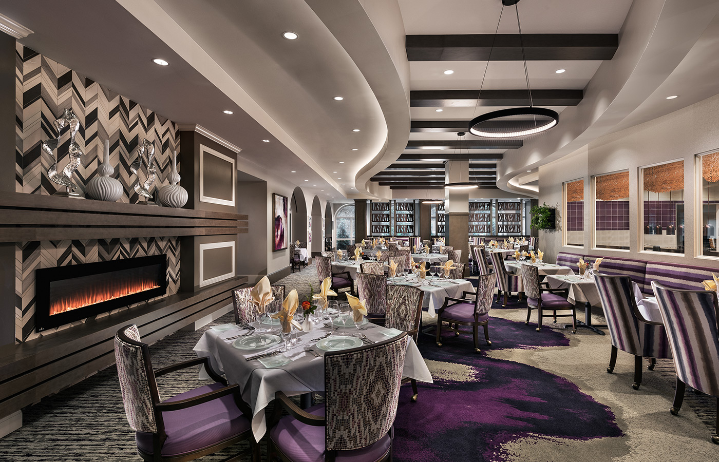 Modern looking dining area filled with tables and chairs.