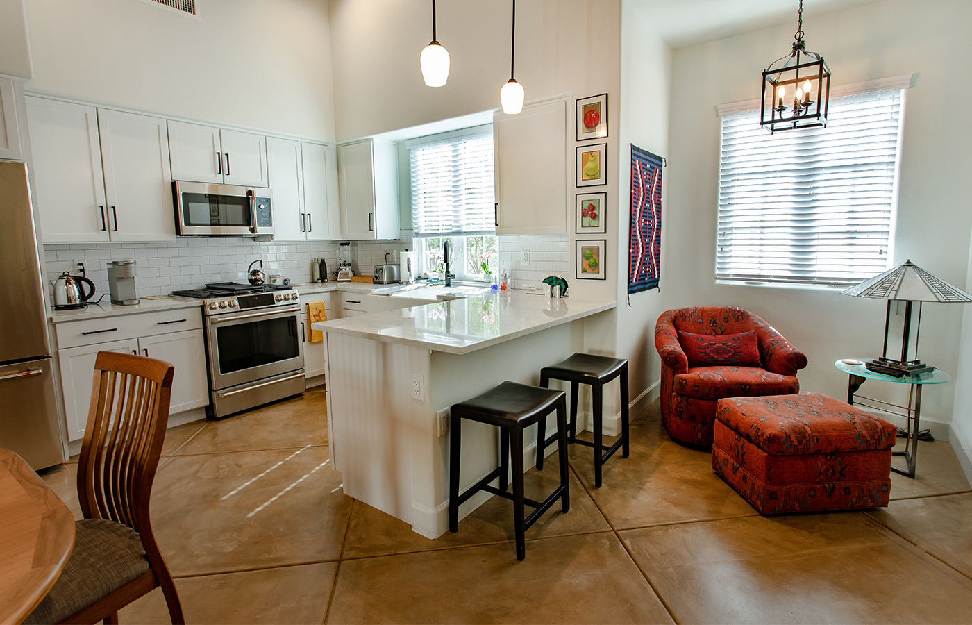 Furnished kitchen with table, cabinets, and refrigerator.