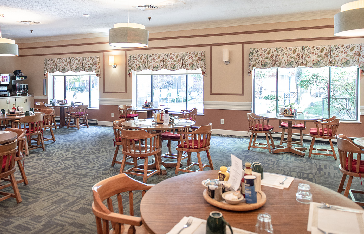 A dining room with tables set for dinner.