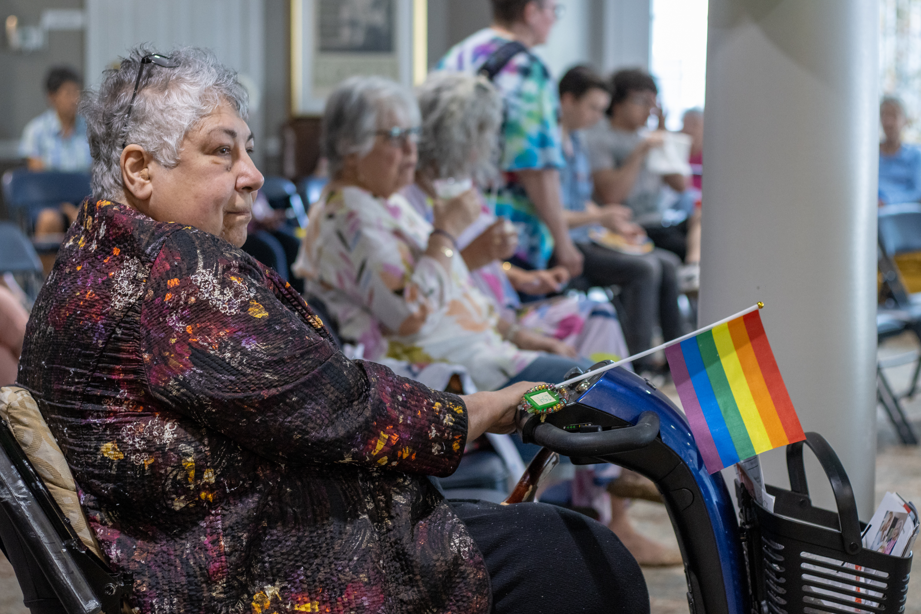wheelchair resident in wheelchair holding pride flag