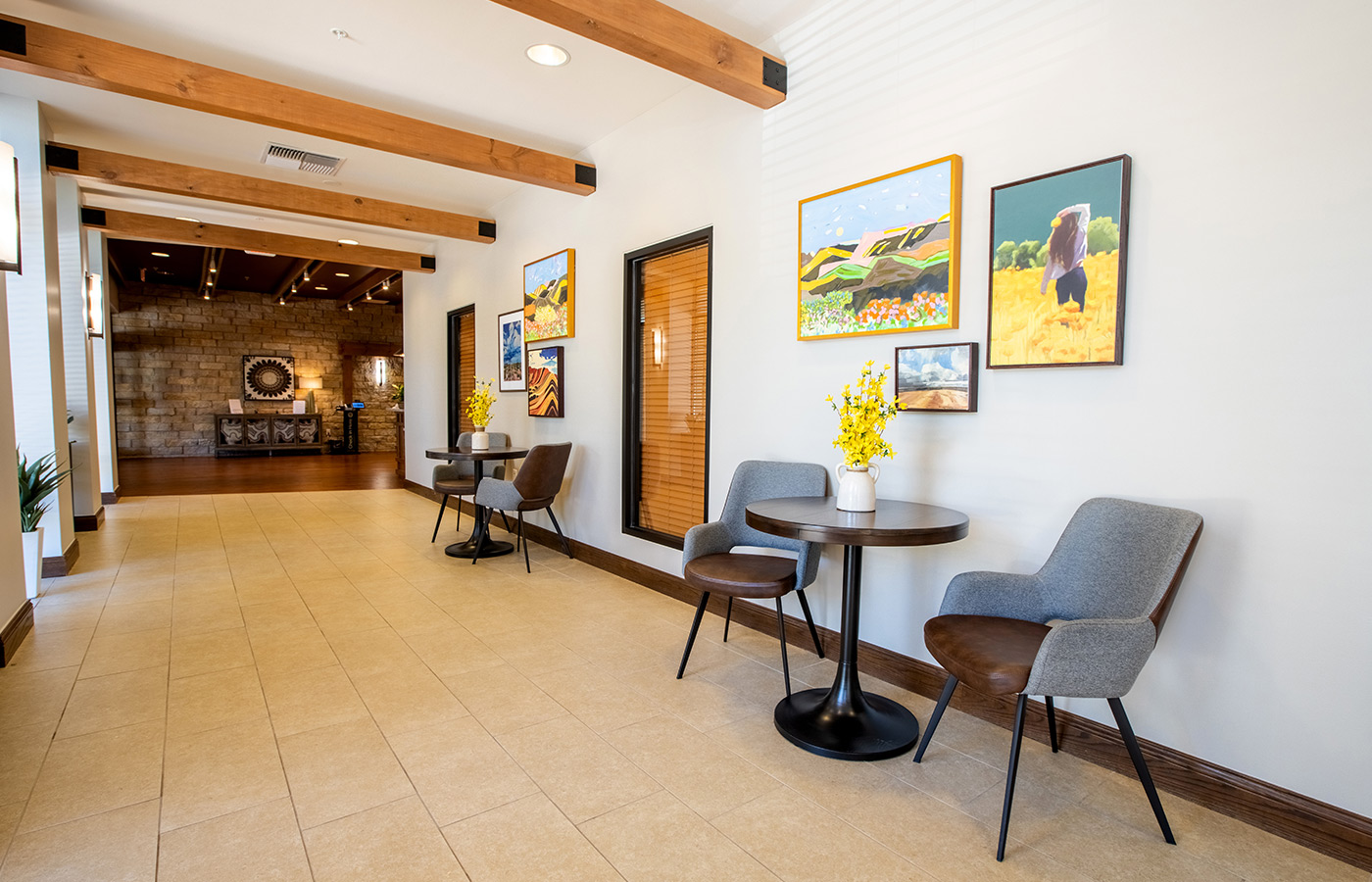 A hallway with seating and a lot of wall art.